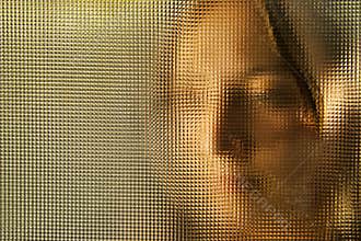 Young girl's face behind glass