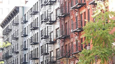 New York City building architecture, Manhattan. Residential house exterior. Red brick, fire escape.
