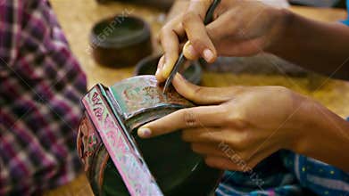 Burma. Artist makes pattern on the product in the workshop