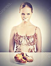 Diet concept. woman mouth sealed with duct tape with buns