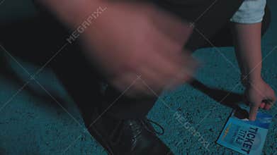 Crouching Person Picking Up a Ticket