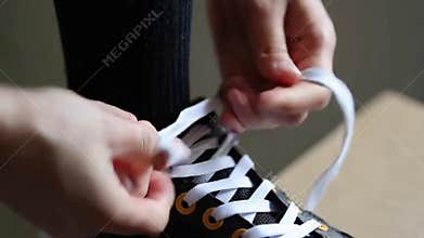 Close,up hands tying shoelaces on white black sneakers preparing activity stock footage Generative AI