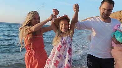 Friendly family walking along the coast in slow