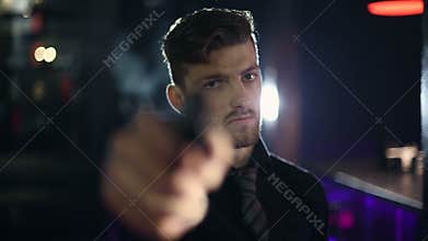 The man pulls out a gun and aims at the viewer