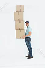 Confident delivery man carrying stack of boxes