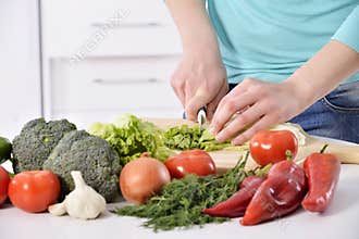 Woman cooking in new kitchen making healthy food with vegetables.