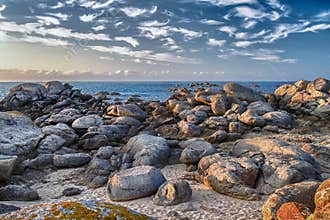 Rocky shore along the coastline of Bretagne during late afternoon with clear skies and calm sea