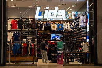 View of Lids store with sports apparel and caps display.