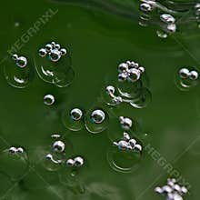 Exploring natural details through macro shots of bubbles in green water creating abstract forms