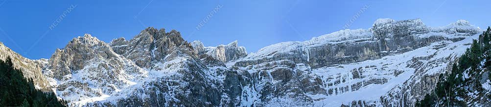 Snow-covered Pyrenees mountains under clear blue sky near the end of winter in daytime
