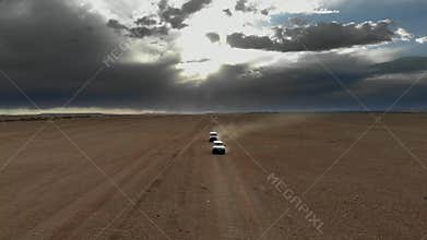 Offroad vehicles cross Gobi Desert dunes in Mongolia through remote sand country, desert convoy, sand dunes, dune crossing