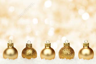 Gold Christmas background with baubles in snow