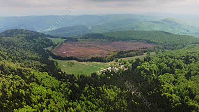 High-altitude aerial view of a crater lake and a forested volcanic pea