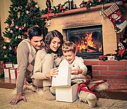 Family near fireplace in Christmas decorated house