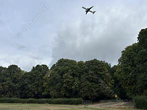Commercial Airplane Flying Over Amsterdam Forest Under Cloudy Sky Netherlands
