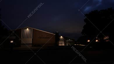 Night exterior of low rise community building with illuminated facade, vertical