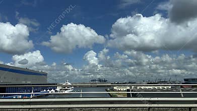Amsterdam waterfront industrial skyline with harbor buildings, cargo cranes, wind