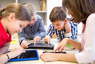 Group of school kids with tablet pc in classroom
