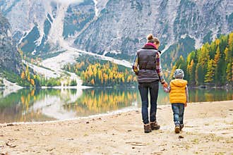 Mother and baby walking on lake braies in italy