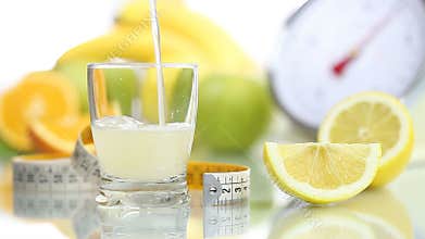 Lemon juice poured in glass, fruit meter scales diet food