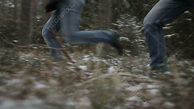 Two men running through the woods. Slow motion