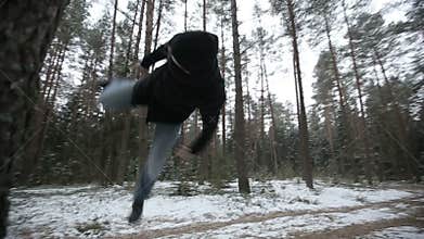 Man running through the woods and doing parkour jump. Slow motion