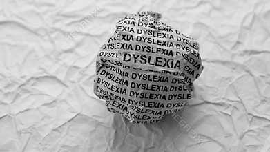 Crumpled paper ball with words Dyslexia on a crumpled white paper background
