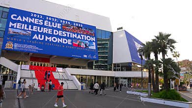 Palais des Festivals Cannes steps with banner and pedestrians
