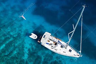 Amazing view to yacht, swimming woman and clear water in caribbean paradise