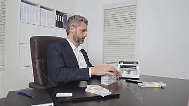 Businessman in suit at office desk with money counting machine. Finance expert. Banker money counting in office. Financial control