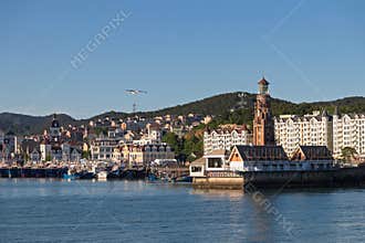 Dalian, China-June 5, 2026: Harbor town waterfront with clock tower seagull flying over calm sea at Fisherman’s Wharf