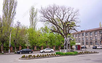 Statue surrounded by greenery and parked cars
