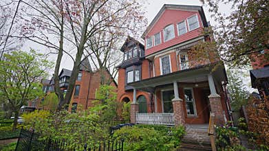 Low angle moving shot of victorian style houses on residential street in Toronto neighbourhood, Ontario, North America