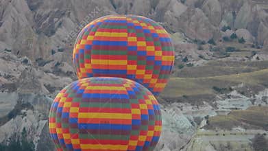 Hot air balloons drift above Cappadocia fairy chimneys and volcanic valleys at sunrise, sky, balloon panorama, dawn light, turkiye