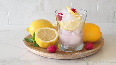 Pouring of a glass of refreshing summer pink lemonade