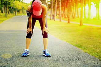 Tired woman runner taking a rest after running hard