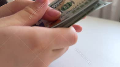 One hundred dollar bills counted, displayed and arranged on white background, large stack of United States cash for