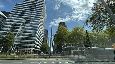 Modern high-rise office towers along wide urban street with tram lines