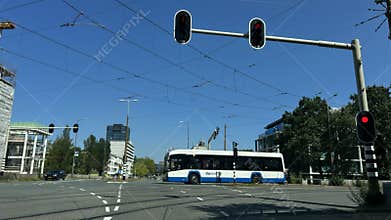 Urban intersection with electric city bus, red traffic signals, overhead transit