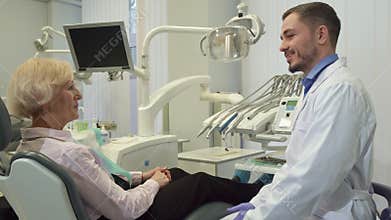 Dentist greets female client at his office