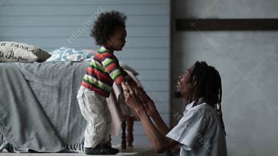 Playful hipster dad playing with his son at home