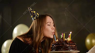 Happy Emotional Girl Blows out Candles During Celebration Her Birthday and Applauds. Close up Portrait of Young Lady