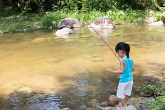 Asian Chinese little girl angling with fishing rod