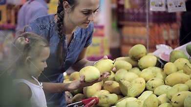 Mother with little daughter makes purchases in the supermarket