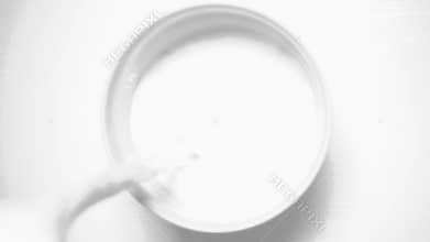 Slow motion white milk in a white cup