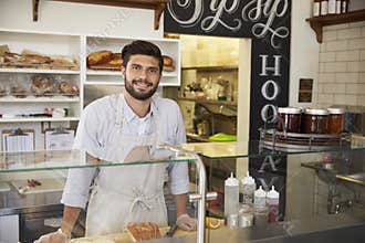 Small business owner behind the counter of a sandwich bar