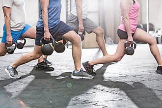 Low section of people lifting kettlebells at crossfit gym