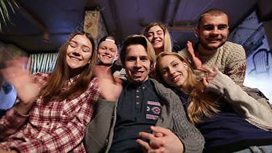 Group of happy teenage friends waving hands