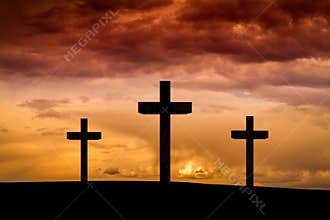 Jesus Christ cross on a red, orange sky with dramatic clouds, dark sunset