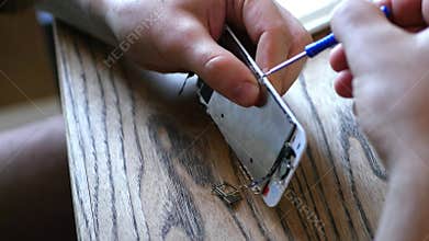 Master, fastens the small parts of the broken phone, gushes the screen to the panel with a small screwdriver. 4K 30fps